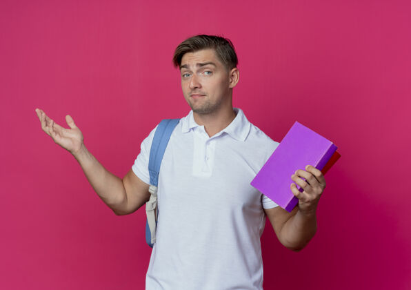 年轻高兴的年轻帅气的男生背着书包拿着书男性粉色手持