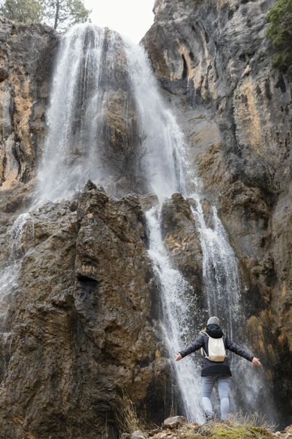 冒险瀑布里的女人背包旅游探索