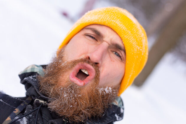 旅行一个留着胡子的男人的近照 所有的脸都在雪地里 在雪林里散步风景自然