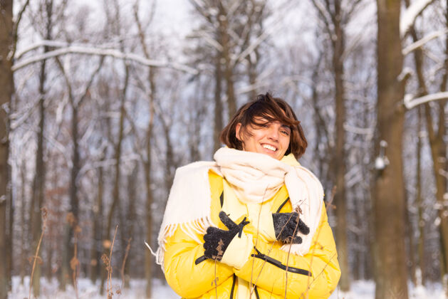 信心美丽的年轻开朗的女人在雪景的冬日森林里玩得很开心 穿着暖和的衣服在冬天和雪里快乐冬天雪美丽