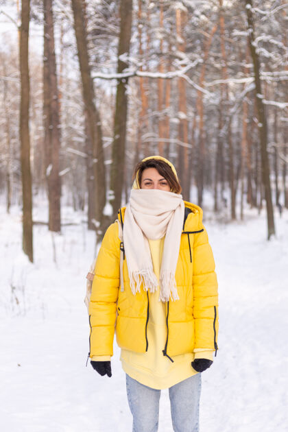 雪美丽的年轻开朗的女人在雪景的冬日森林里玩得很开心 穿着暖和的衣服在冬天和雪里快乐季节站自然