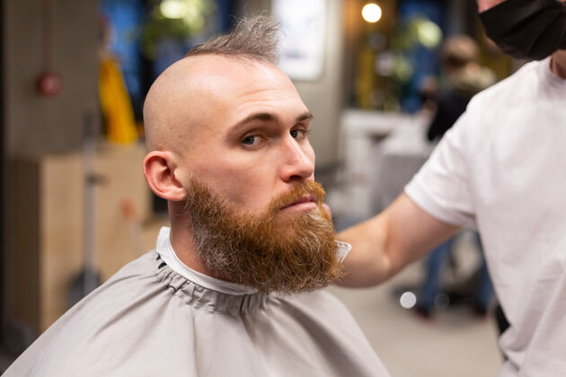 发型师在理发店剪胡子的欧洲野蛮人工作理发师剃须刀