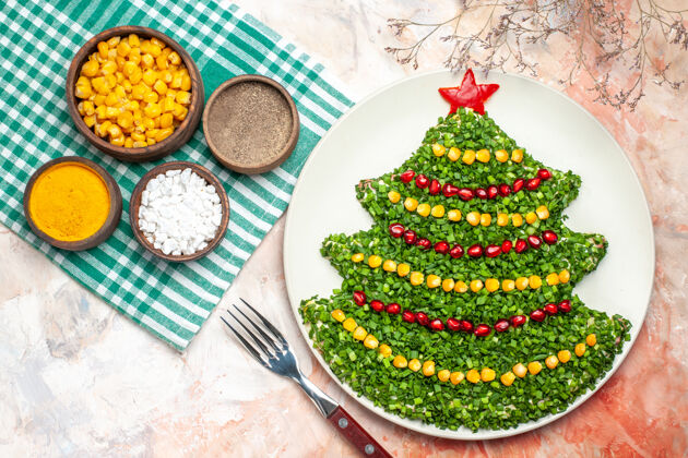 礼物顶视图美味的绿色沙拉在新年树形状与调味品在轻背景树灯光健康