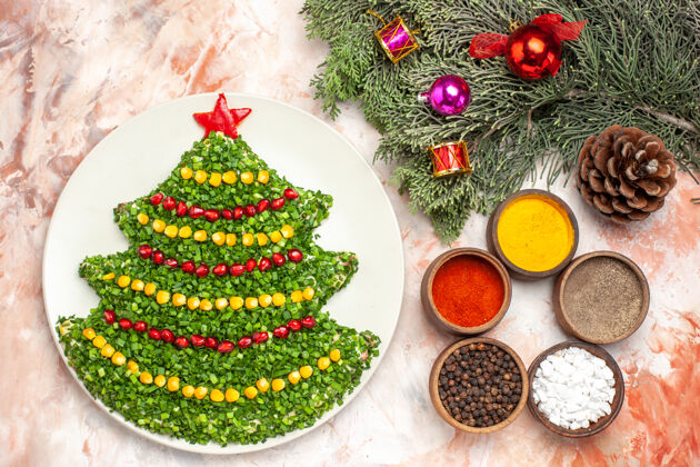 餐顶视图美味的绿色沙拉在新年树形状与调味品在轻背景礼物背景圣诞节