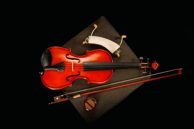 玫瑰小提琴在它的特殊盒子上 它的弓是黑色的演奏光弦乐