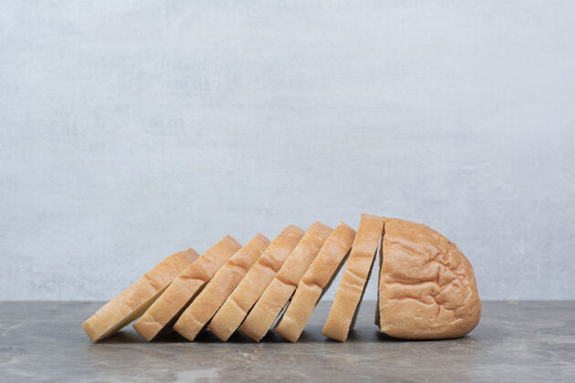 切片把新鲜面包片放在大理石表面食物面包美味