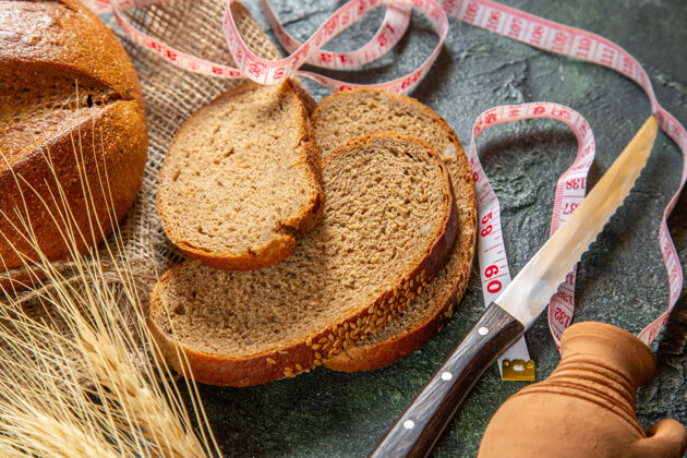 黑面包上图为全黑面包和切好的膳食黑面包 在棕色毛巾米上刺上深色表面钉子切割美味