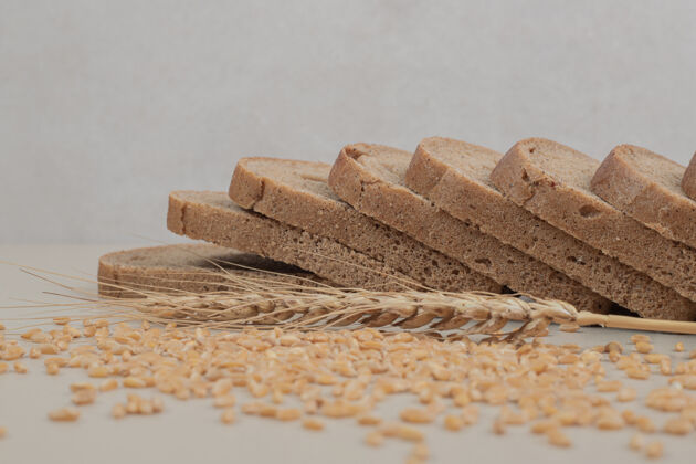 切片切片新鲜的棕色面包 白色表面有燕麦粒脆食品美食
