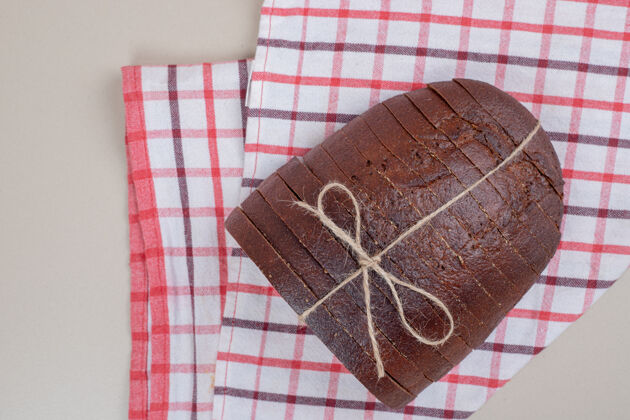 小吃用绳子把新鲜的棕色面包片放在桌布上烘焙面包房食品