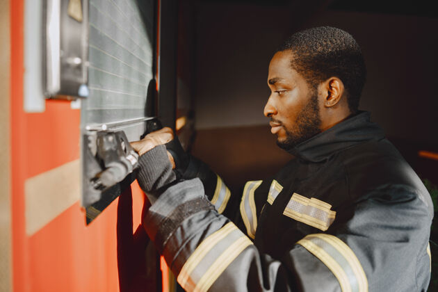 颜色消防员站在消防车前的画像危险设备制服