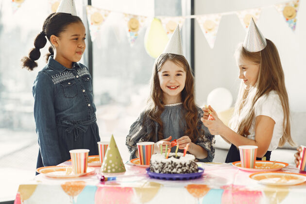 蛋糕儿童有趣的生日聚会在装饰房间快乐的孩子与蛋糕和气球小人房子