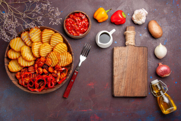 膳食在黑暗的桌子上俯瞰烤土豆和熟蔬菜土豆晚餐蔬菜