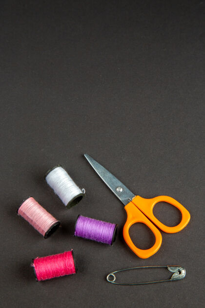 剪刀前视图彩色线用剪刀在黑暗的表面黑暗的衣服缝纫针织妇女缝纫针照片的颜色别针针织衣服