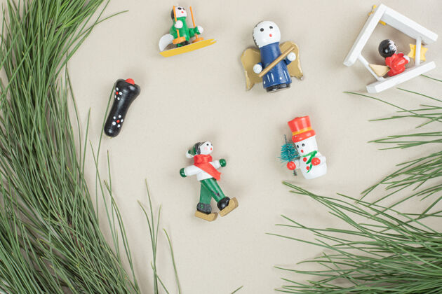 装饰品圣诞玩具和米色表面的树枝节日天使雪人