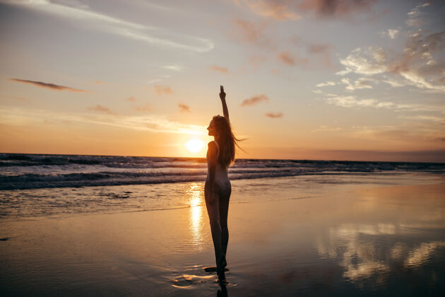 黎明从后面的女孩看海日落全长肖像海洋享受海滩