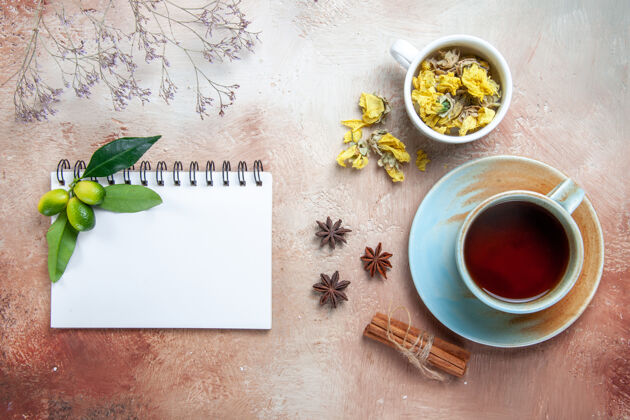 早晨顶部特写查看一杯茶一杯茶肉桂棒草药笔记本笔记本浓缩咖啡茶