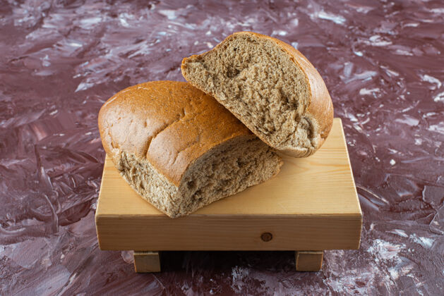 桌子切碎的棕色新鲜面包放在木板上新鲜木材糕点