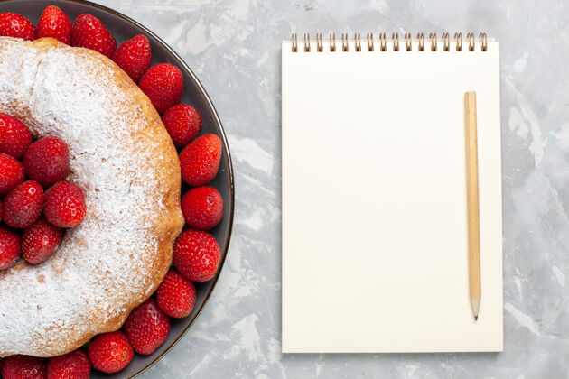 派俯瞰美味的草莓派与笔记本上的浅白色蛋糕笔记本果味