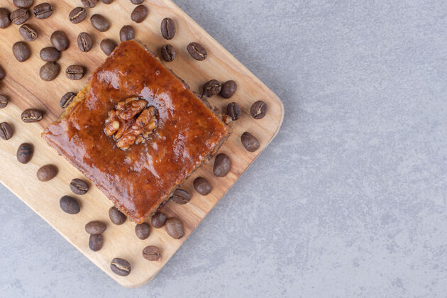 美味在大理石桌上的木板上放上烤面包和咖啡豆甜点糕点美味
