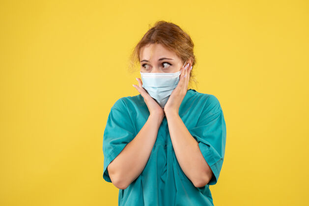 脸黄墙上年轻女医生穿着医疗服 戴着口罩的正面图人面具套装
