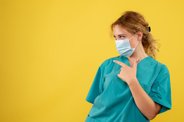 健康黄墙上年轻女医生穿着医疗服 戴着无菌口罩的正面图绝育支持医院