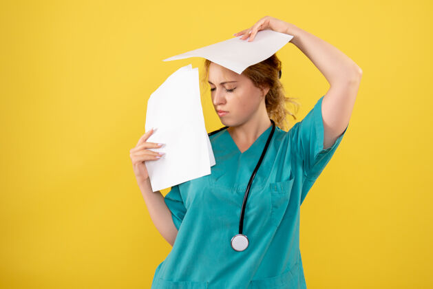 快乐穿着医疗服的女医生正对着黄色的墙上拿着分析帽子帽子医院