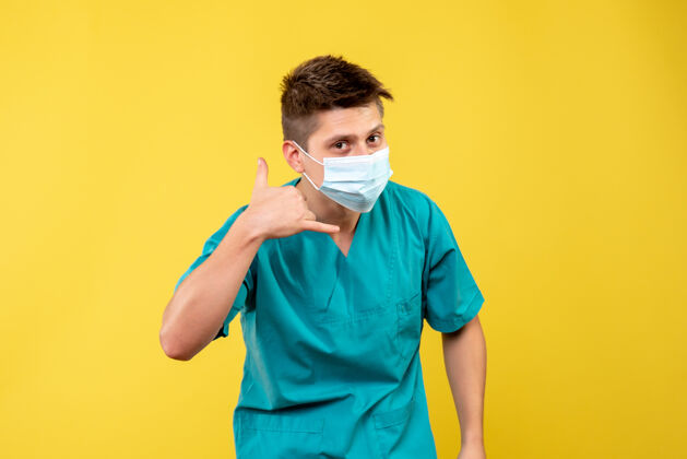 医院身穿医疗服的男医生正面图 黄色墙上有无菌面罩疾病正面人