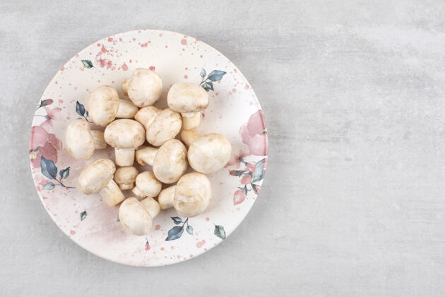 整个成熟的蘑菇放在盘子里 放在大理石桌上健康盘子有机