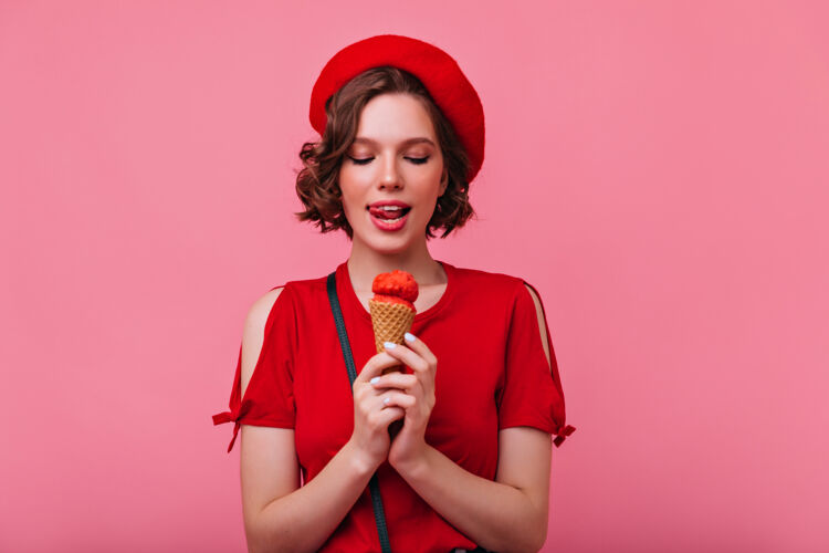 正面优雅的穿着考究的女人在享受甜点卷曲的法国女孩在吃冰淇淋成人享受贝雷帽