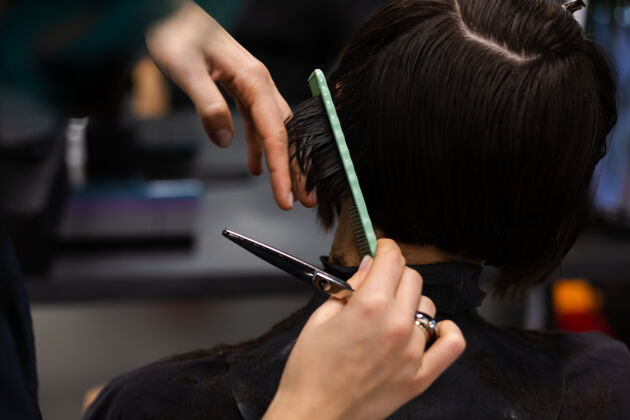 面膜一个专业的女理发师给客户理发这个女孩戴着面具坐在美容院里顾客设备理发师