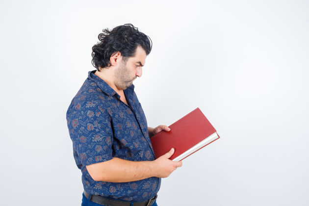 中年一幅中年男人穿着衬衫看着书 看着深思熟虑的前景色的画像50多岁专业年龄