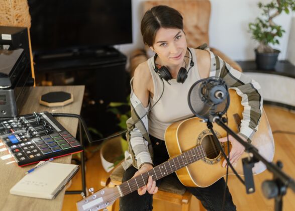 爱好有创意的女人在家里练习一首歌媒体专业制作