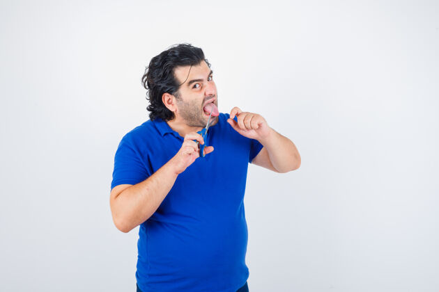 舌头一幅成年男子穿着蓝色t恤试图用剪刀割断舌头的画像 正面看起来咄咄逼人压力男性剪