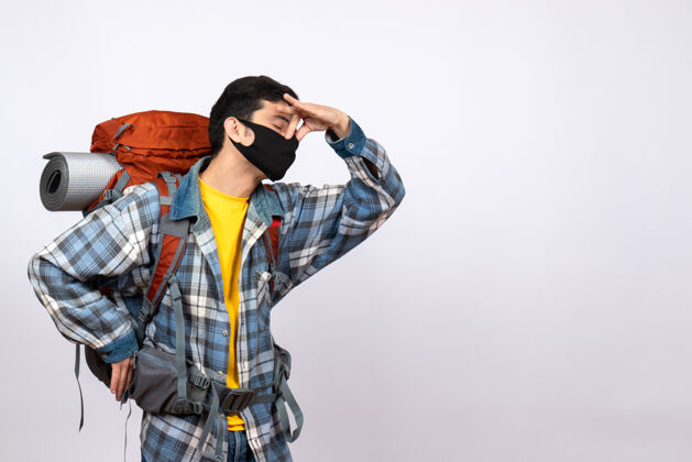 前面正面图：背着背包 戴着面罩 闭着眼睛抱着鼻子的男性旅行者关闭面具鼻子