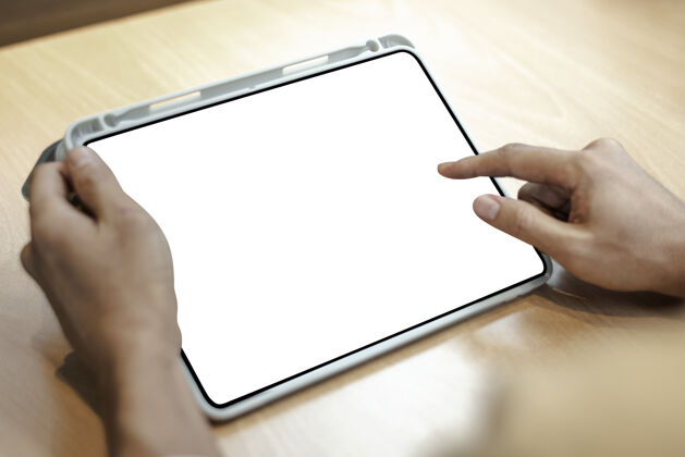 触摸轻木桌上的空白数字平板电脑人数字设备屏幕