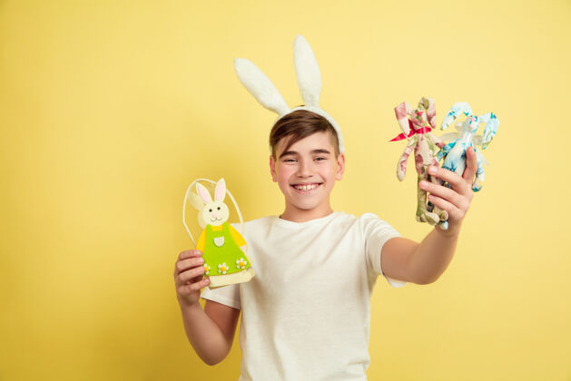 肖像白人男孩作为复活节兔子在黄色工作室背景男孩人类有趣