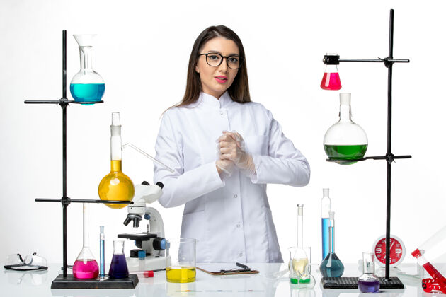 正面前视图穿着医疗服的女化学家在白色办公桌上工作 实验室病毒冠状病毒-大流行科学药品办公桌烧杯