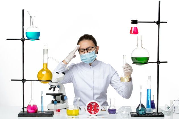 实验室前视图：身穿白色医疗服的女化学家 带面罩 背景为浅白色 化学家实验室病毒冠状病毒飞溅实验室前面设备