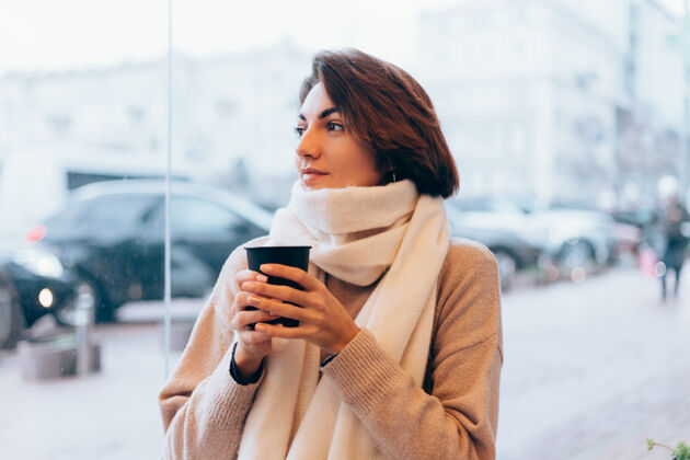 桌子一个女孩在舒适的咖啡馆里用一杯热咖啡取暖咖啡馆女人冬天