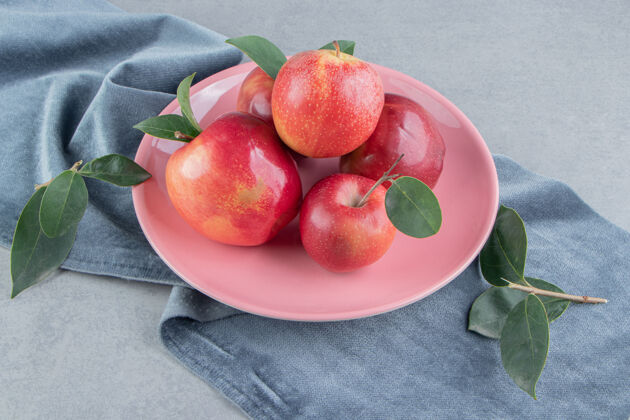 健康在大理石上的一块布料上的盘子上放着一小堆苹果配料有机风味