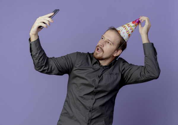 男人戴着生日帽的快乐帅哥拿着紫色墙上的电话看了看紫色电话帅气