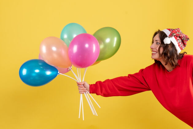 庆祝正面图年轻女性手持黄色气球举行聚会颜色
