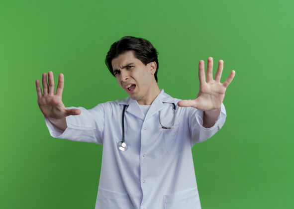 男性穿着医用长袍和听诊器的年轻男医生看起来没有做任何孤立的动作医疗手势人