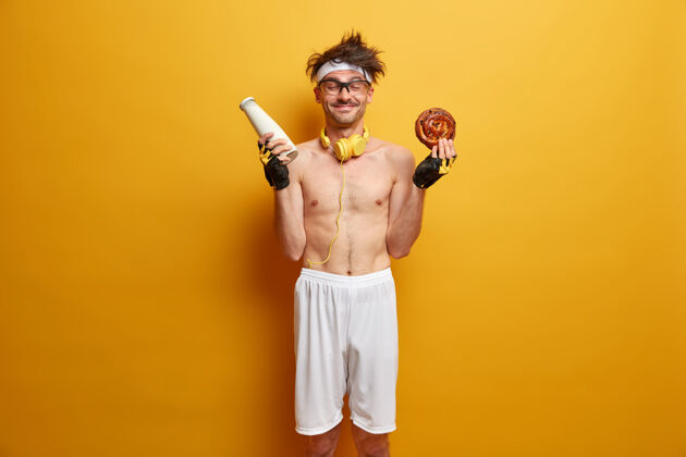 成人运动和减肥概念积极的运动员有吃牛奶面包的诱惑 打破饮食习惯 在健身房锻炼后感到饥饿 穿着运动服 隔着黄色的墙活动运动员白种人