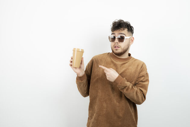 模特戴眼镜的年轻人手里拿着一杯咖啡咖啡眼镜男人