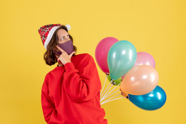 消毒正面图年轻女性隐藏在无菌面具气球圣诞妇女节日色彩情感新年圣诞节情绪快乐