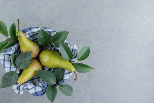 健康梨子和叶子放在一个碗里 用毛巾盖在大理石上配料毛巾碗