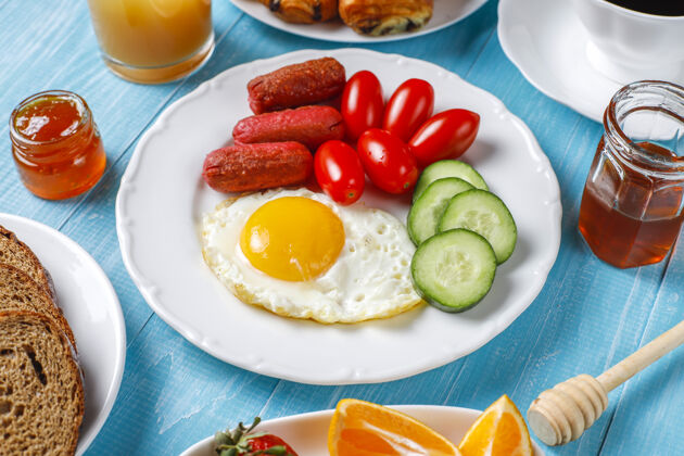 顶部早餐盘子里有鸡尾酒香肠 煎蛋 樱桃番茄 糖果 水果和一杯桃子汁土耳其食物午餐