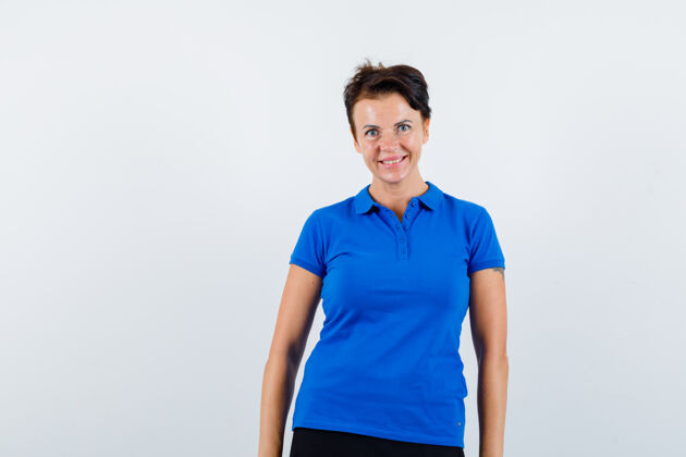 休闲成熟的女人穿着蓝色t恤看着相机 看起来很快乐前视图成熟健康老年