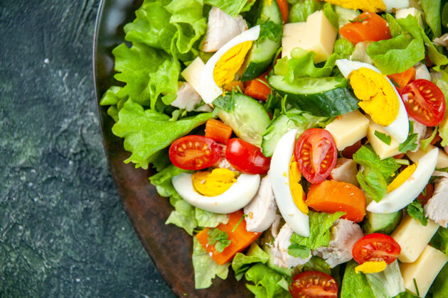 饮食特写镜头自制美味沙拉在一个黑色的盘子左边绿色黑色混合色背景与自由空间蔬菜盘子食物